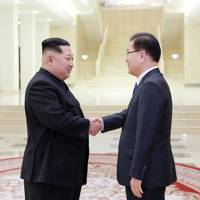North Korean leader Kim Jong-Un (L) shakes hands with South Korean chief delegator Chung Eui-yong (R) during negotiations