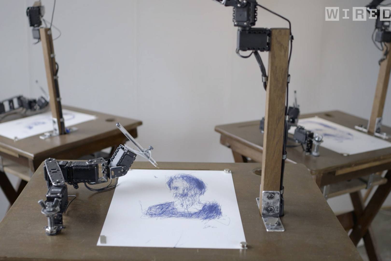 Watch robots in an art class draw portraits of people